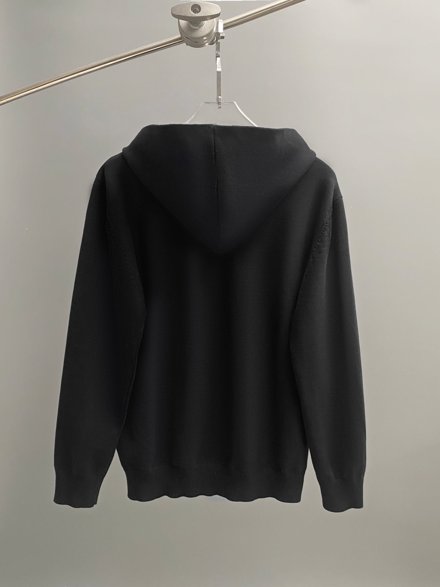 Black hoodie back view with hood and long sleeves.