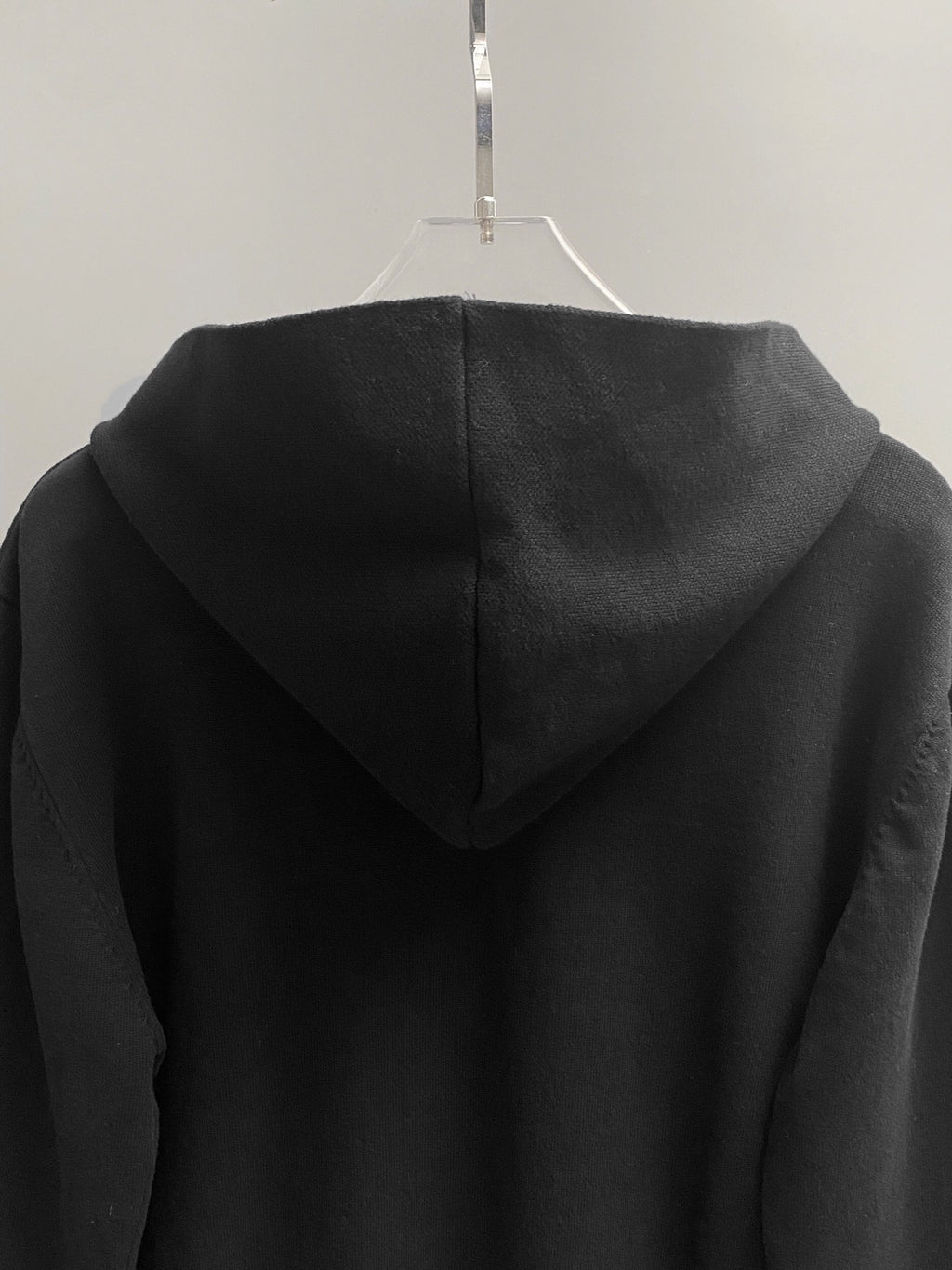 Black hoodie back with hood and ribbed cuffs.