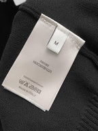Black hoodie fabric tag showing size M, 100% cotton, Made in Italy.