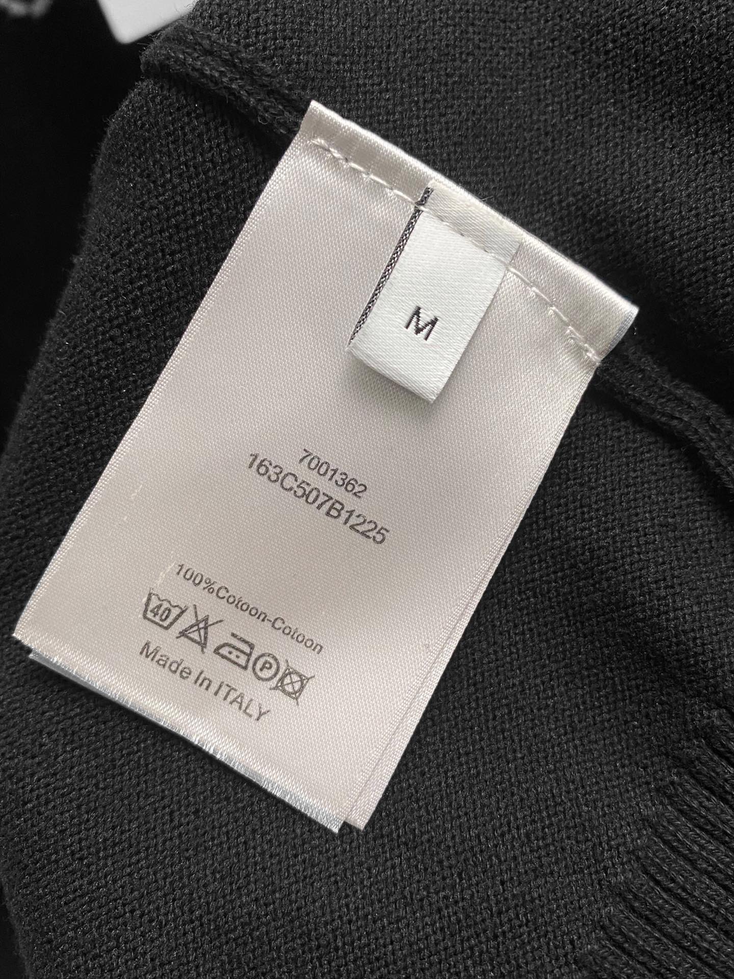 Black hoodie fabric tag showing size M, 100% cotton, Made in Italy.