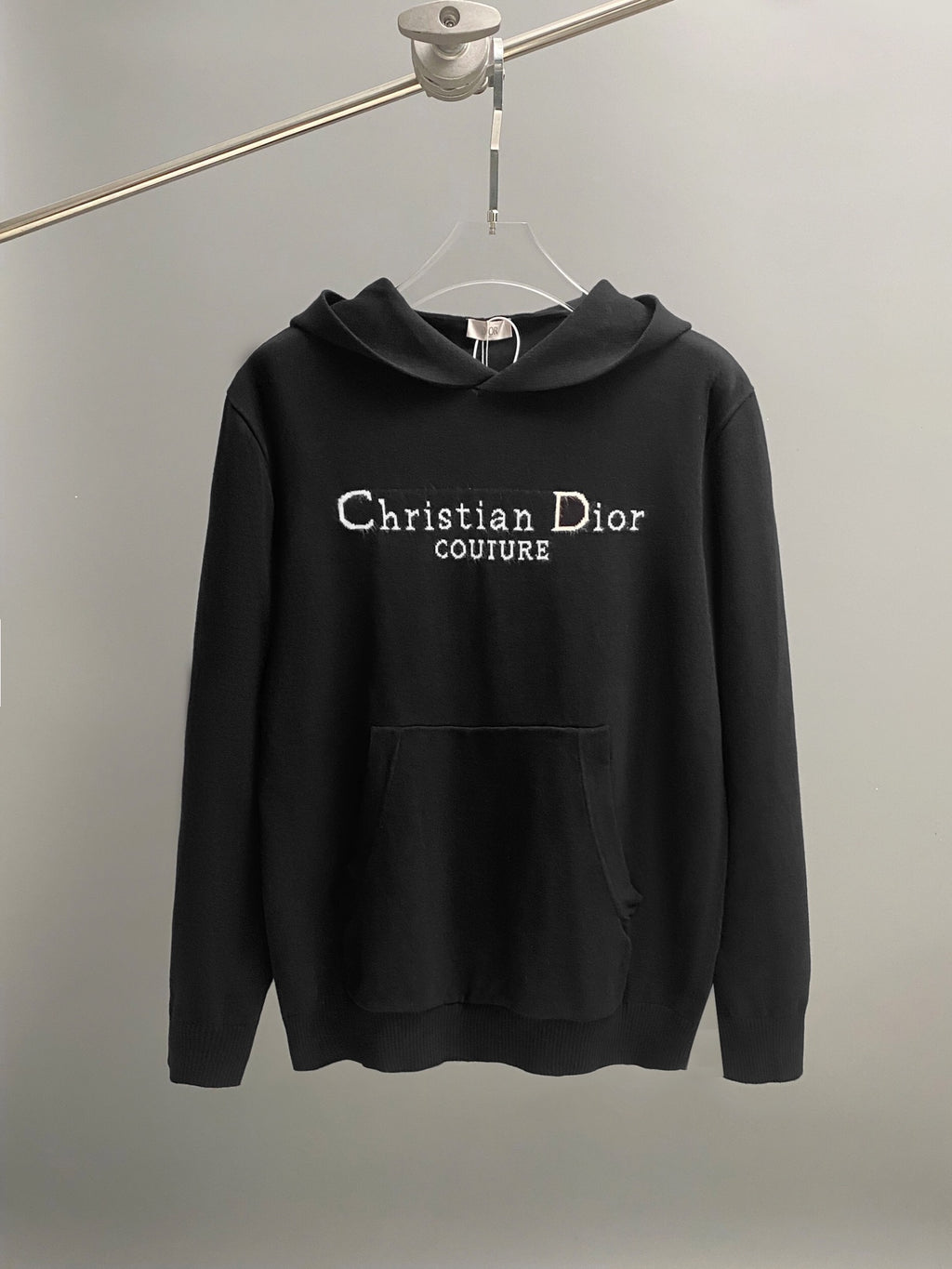 Black long-sleeve hoodie with hood, front pocket, and Christian Dior Couture print.