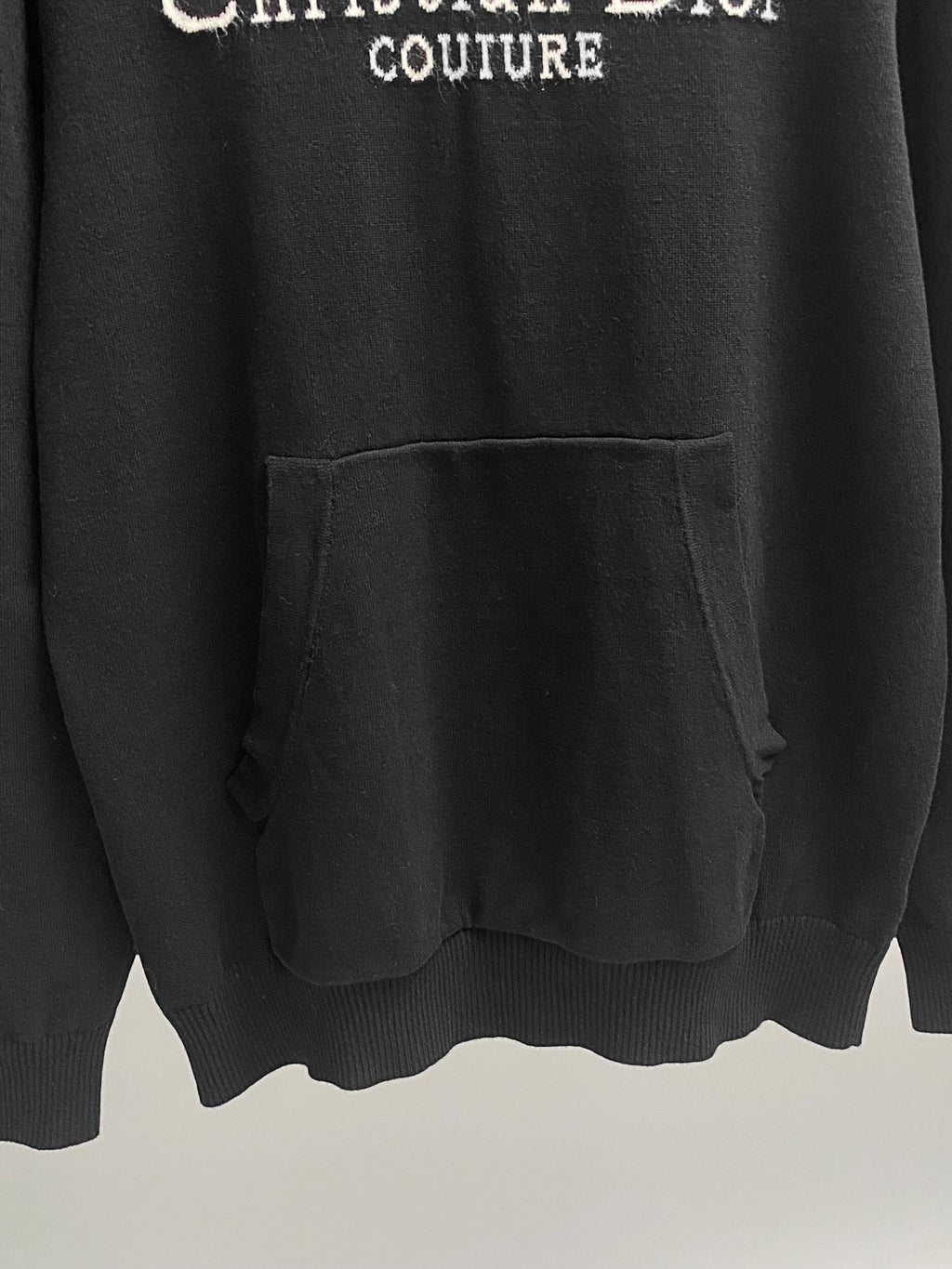 Black hoodie with front kangaroo pocket and ribbed hem.