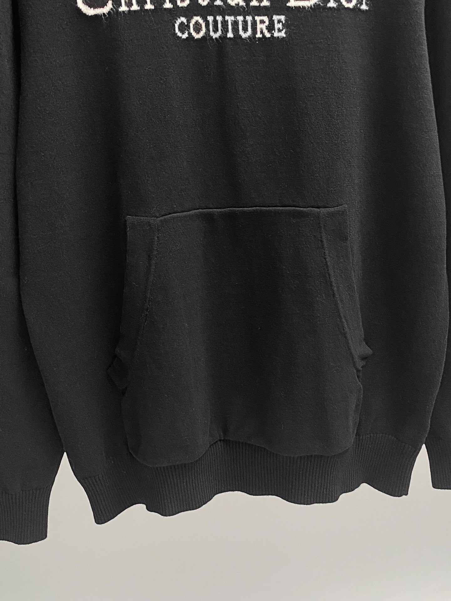 Black hoodie with front kangaroo pocket and ribbed hem.