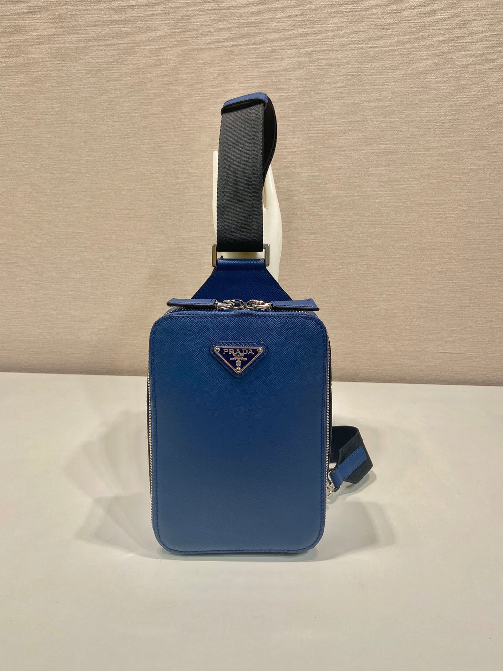 Blue mini crossbody bag with Prada triangle logo and adjustable shoulder strap