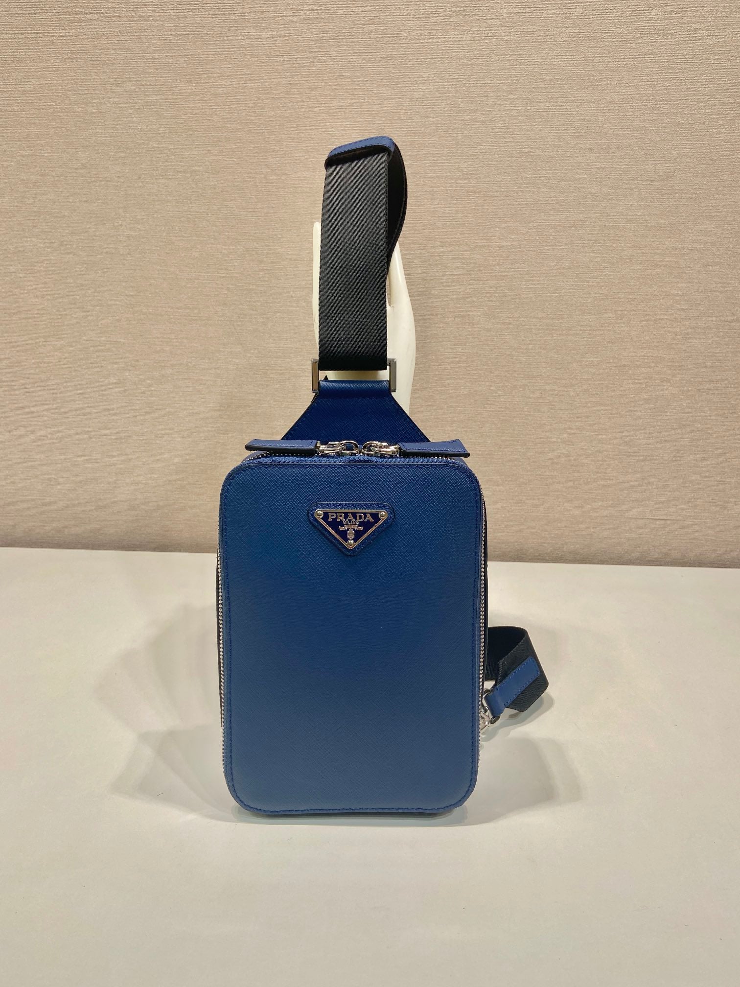Blue mini crossbody bag with Prada triangle logo and adjustable shoulder strap