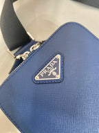 Blue textured leather bag with Prada logo patch on the front panel