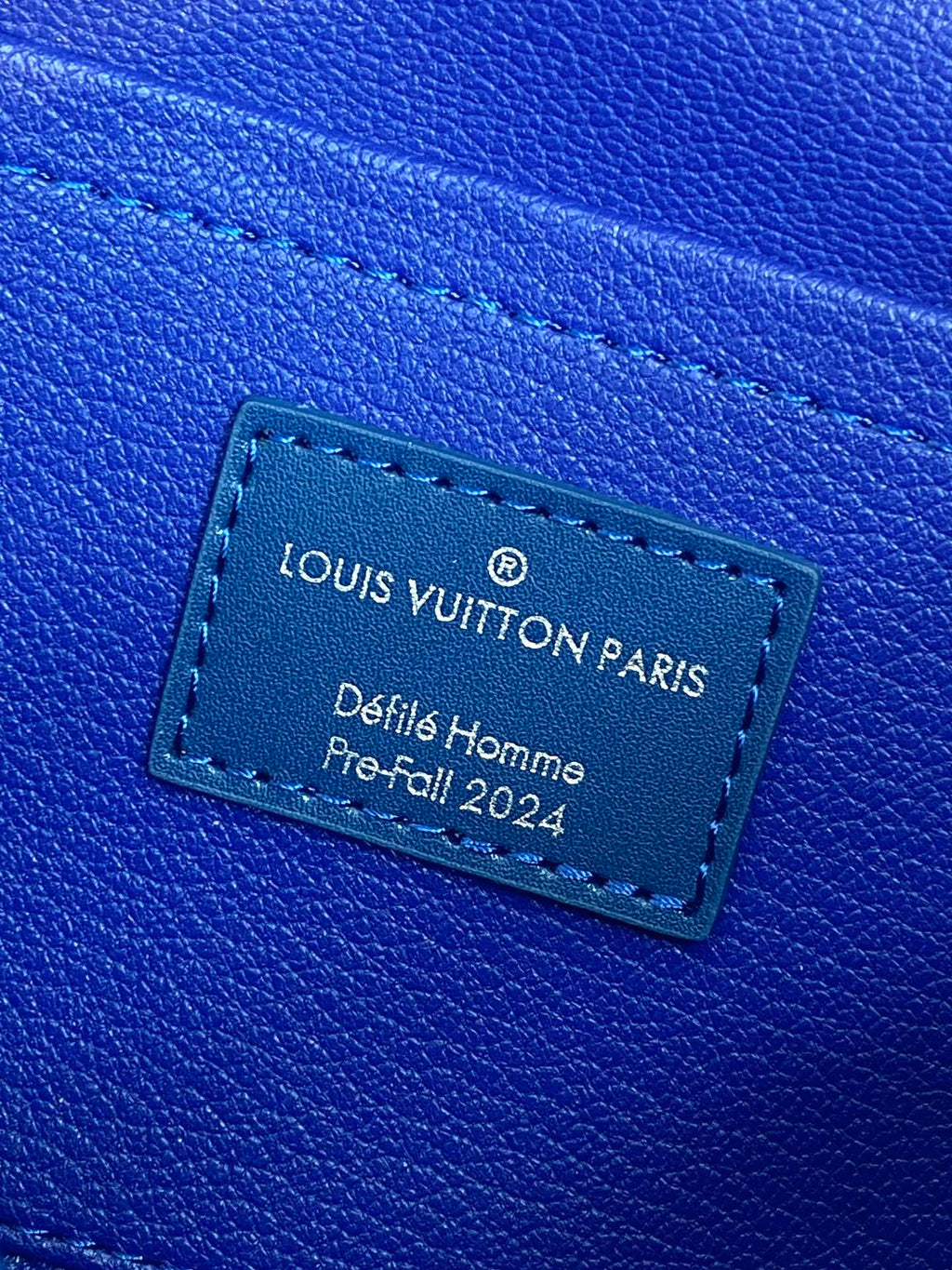 Louis Vuitton blue leather luggage tag with “Louis Vuitton Paris” text