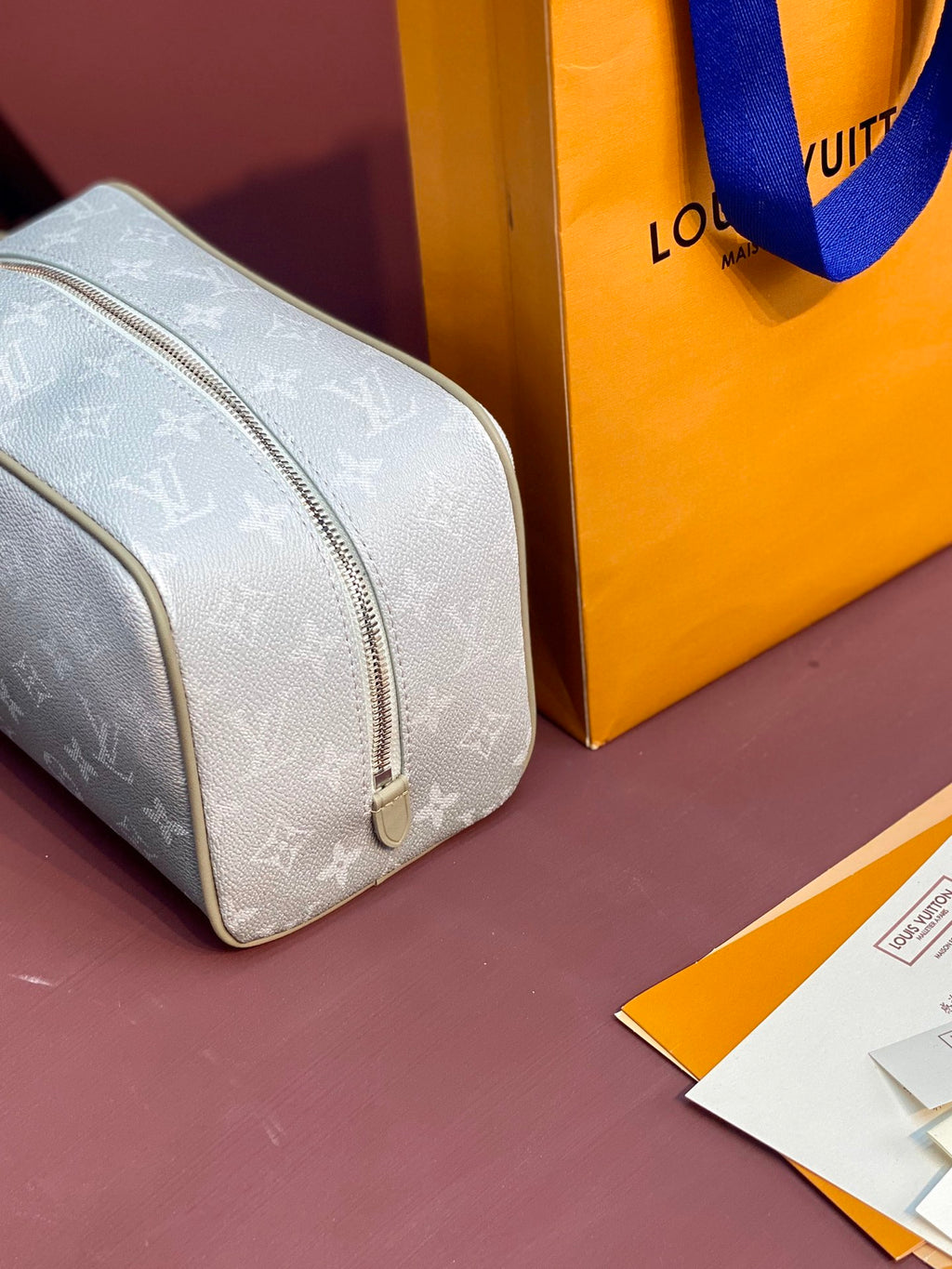 Louis Vuitton monogram pouch bag angled view with top zipper, light blue