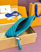 Teal Louis Vuitton small bag with open zipper and monogram, shown next to box