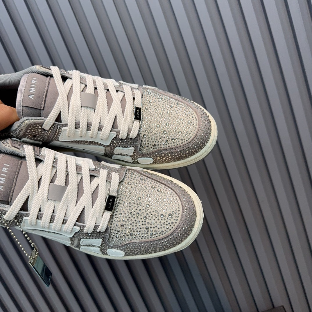 Pair of low-top sneakers with silver glitter uppers, white laces, and blue tag detail