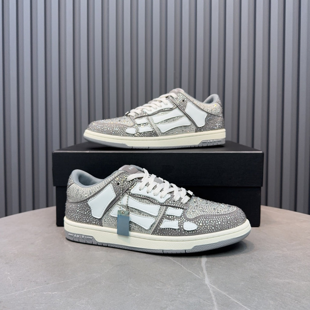 Low-top sneaker on box with silver speckled upper, white logo panel, and lace-up design