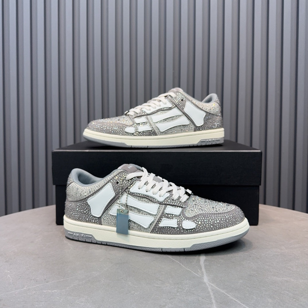 Low-top sneaker on box with silver speckled upper, white logo panel, and lace-up design
