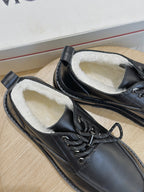 Black leather lace-up shoe close-up, stitched details, textured laces and cushioned lining.
