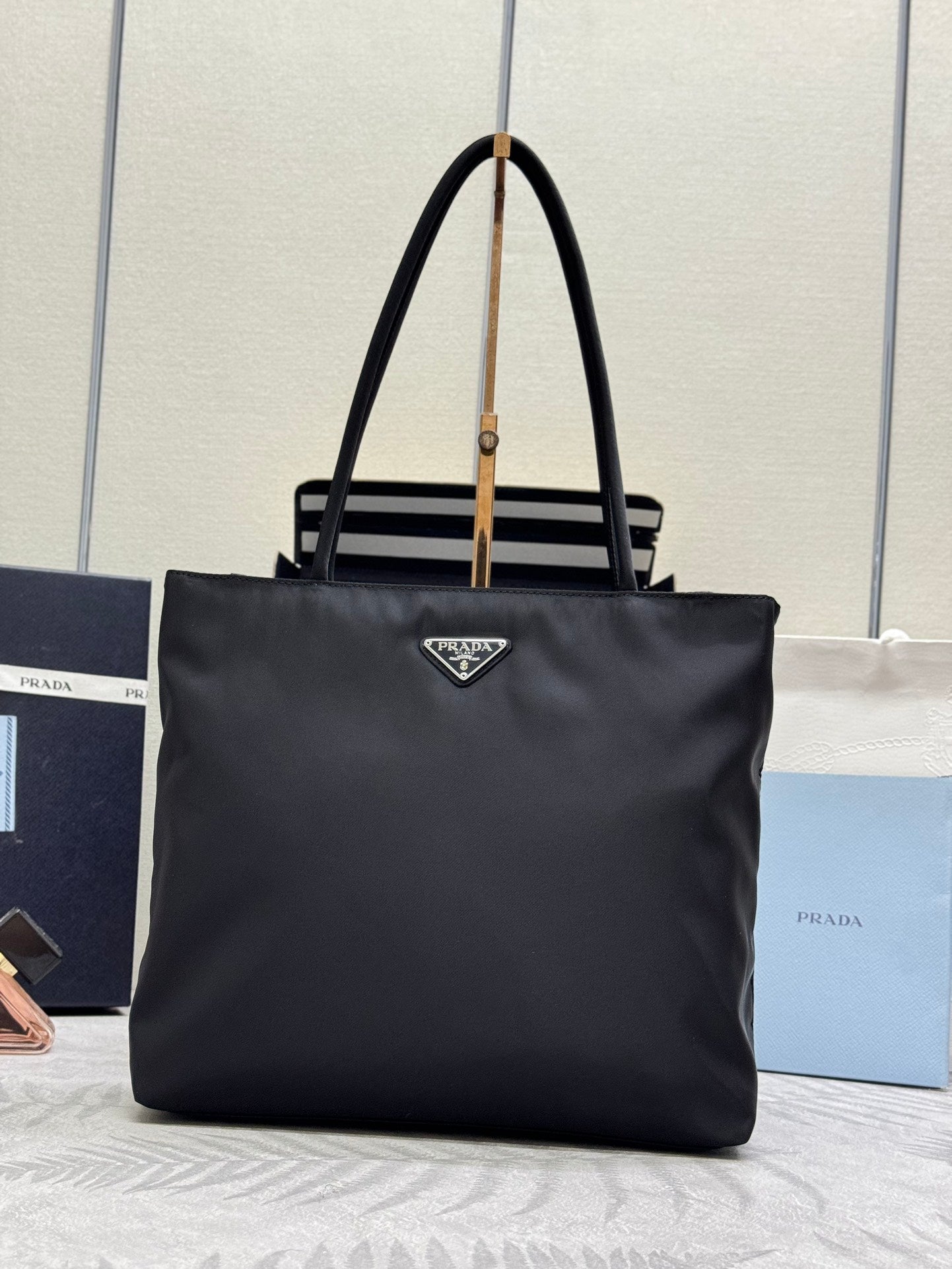 Prada tote bag with top handles, front triangle logo patch, magnetic closure