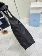 Prada tote bag with long strap, black fabric, and vertical seam detail