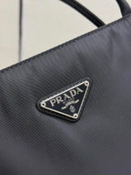 Prada logo patch on dark fabric, triangular metal emblem
