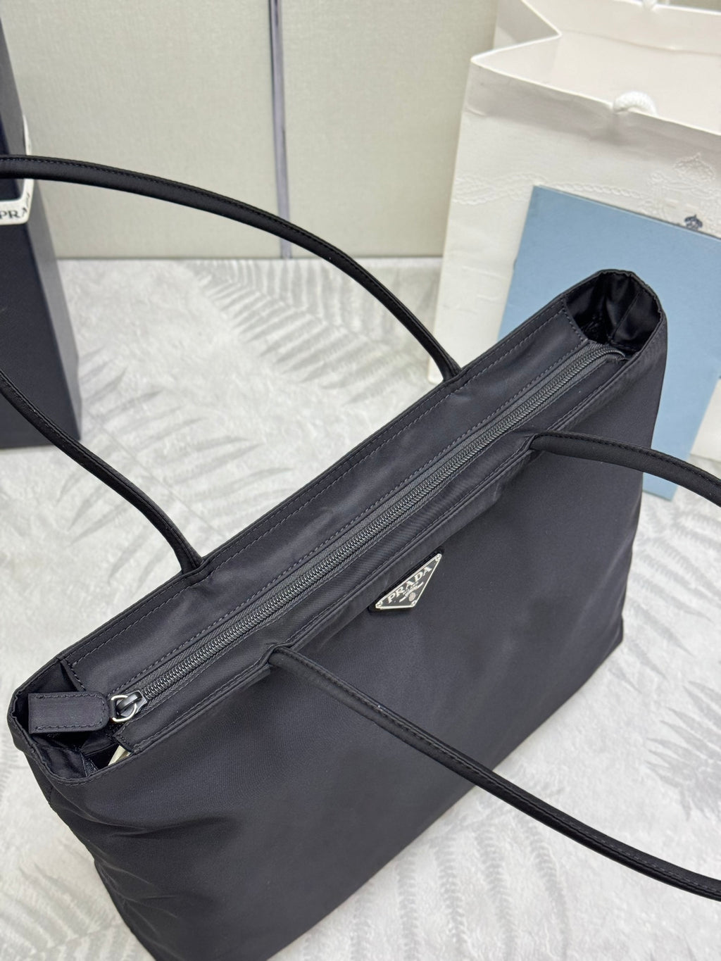 Prada tote bag close-up with front zipper pocket and triangular logo