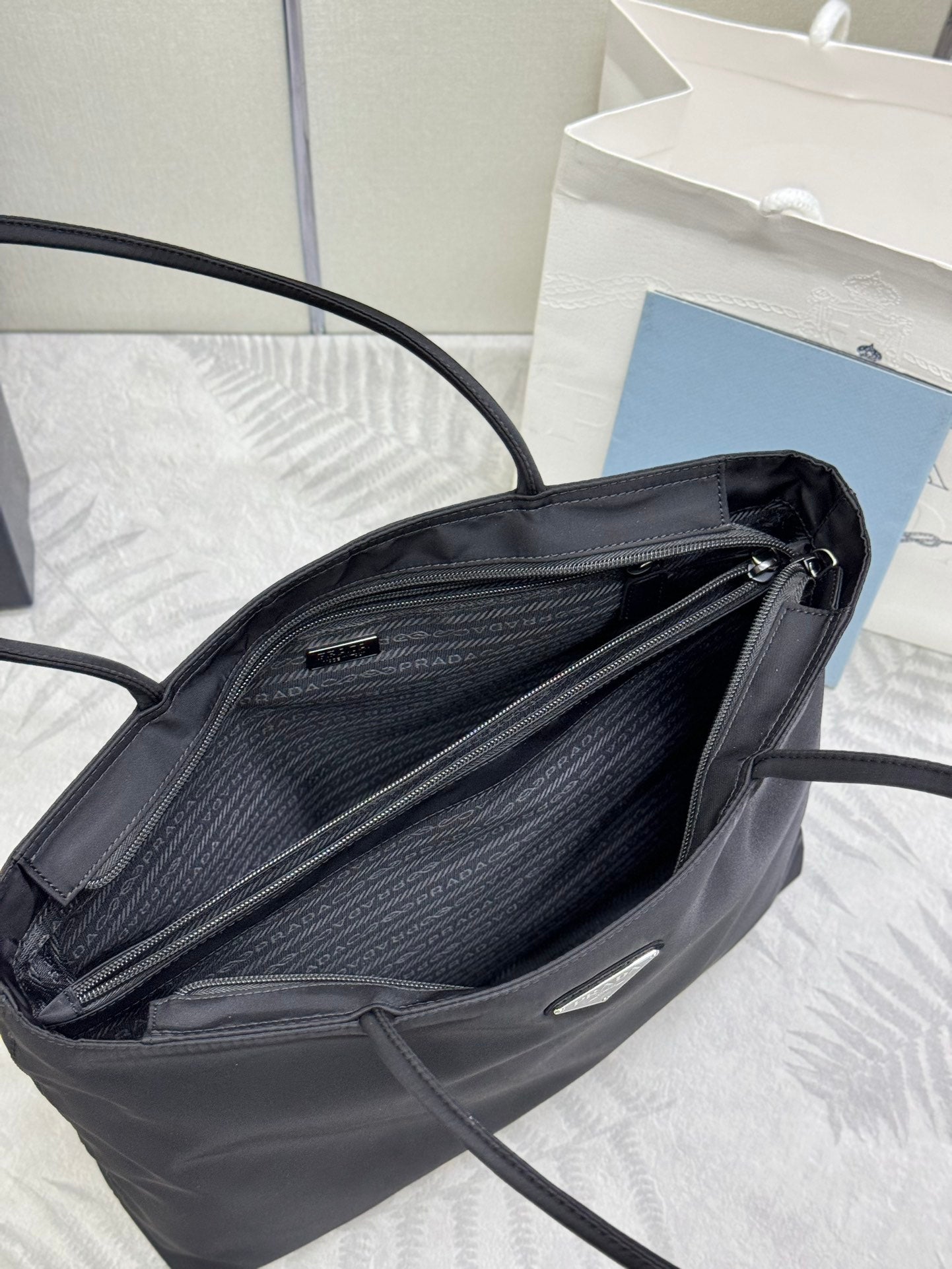 Prada tote bag open view showing dark inner lining and interior zip pocket