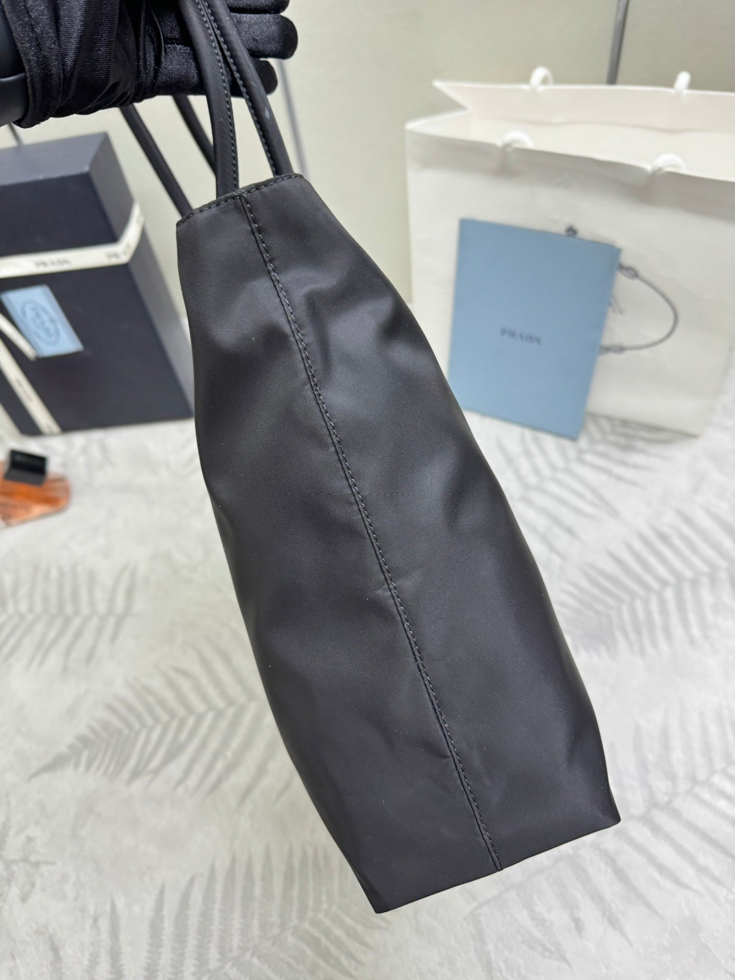 Prada long tote accessory in dark fabric with stitched seam detailing