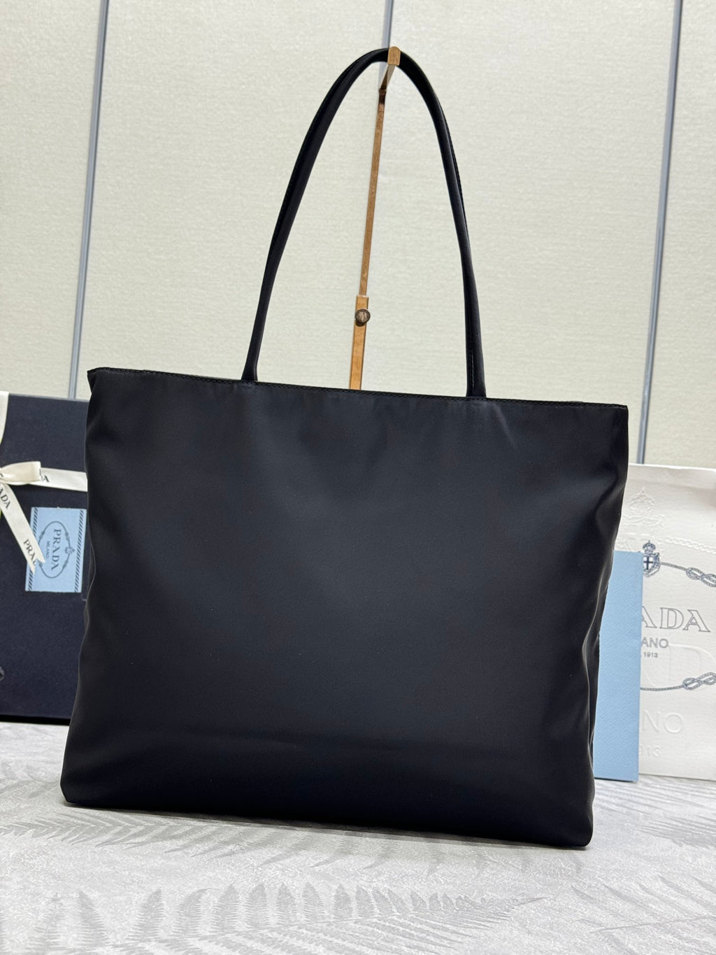 Prada tote bag with long dark handles and triangular logo on front
