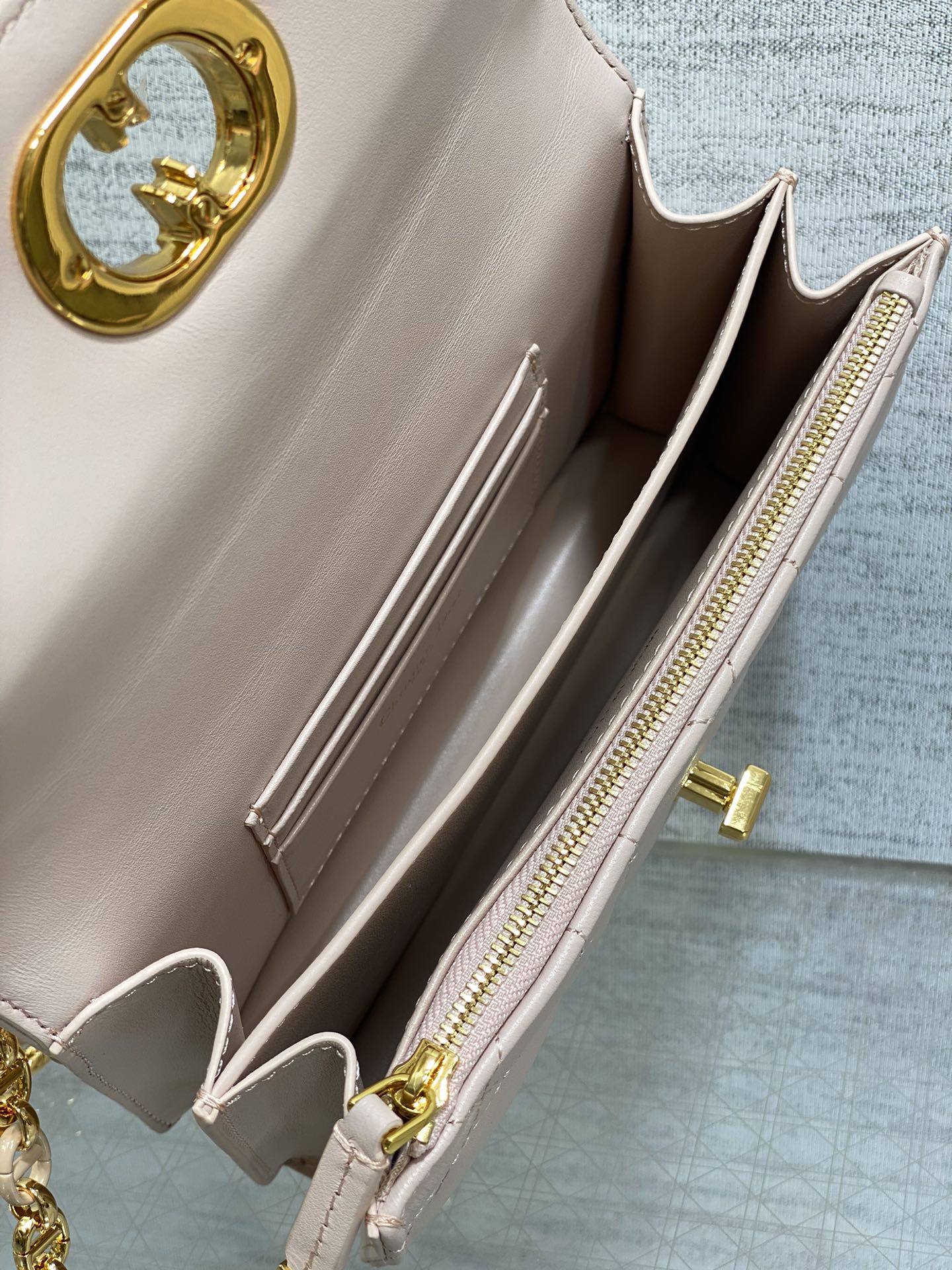 Dior bag interior view with dual zip pockets and gold zipper pulls