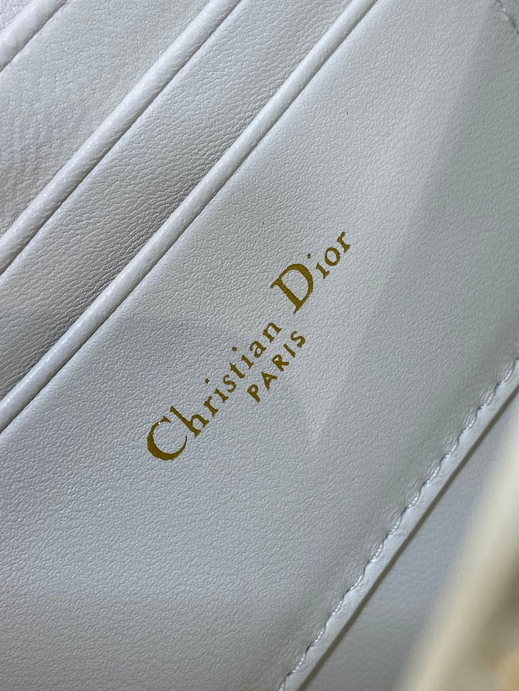 Dior handbag interior label with 'Christian Dior' text on white leather