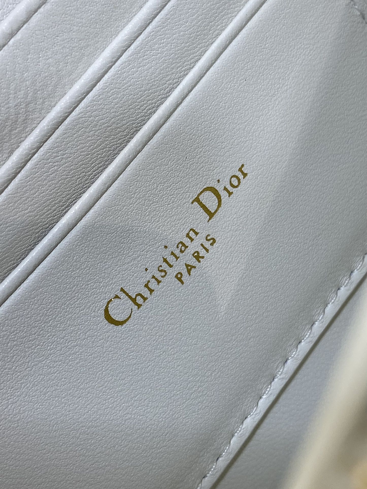 Dior handbag interior label with 'Christian Dior' text on white leather