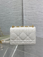 Dior handbag side view in white quilted leather with gold chain strap
