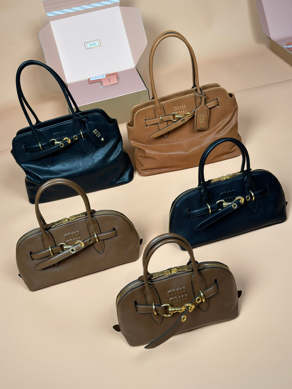 Assorted Miu Miu handbags with top handles in navy, tan, and dark green shades