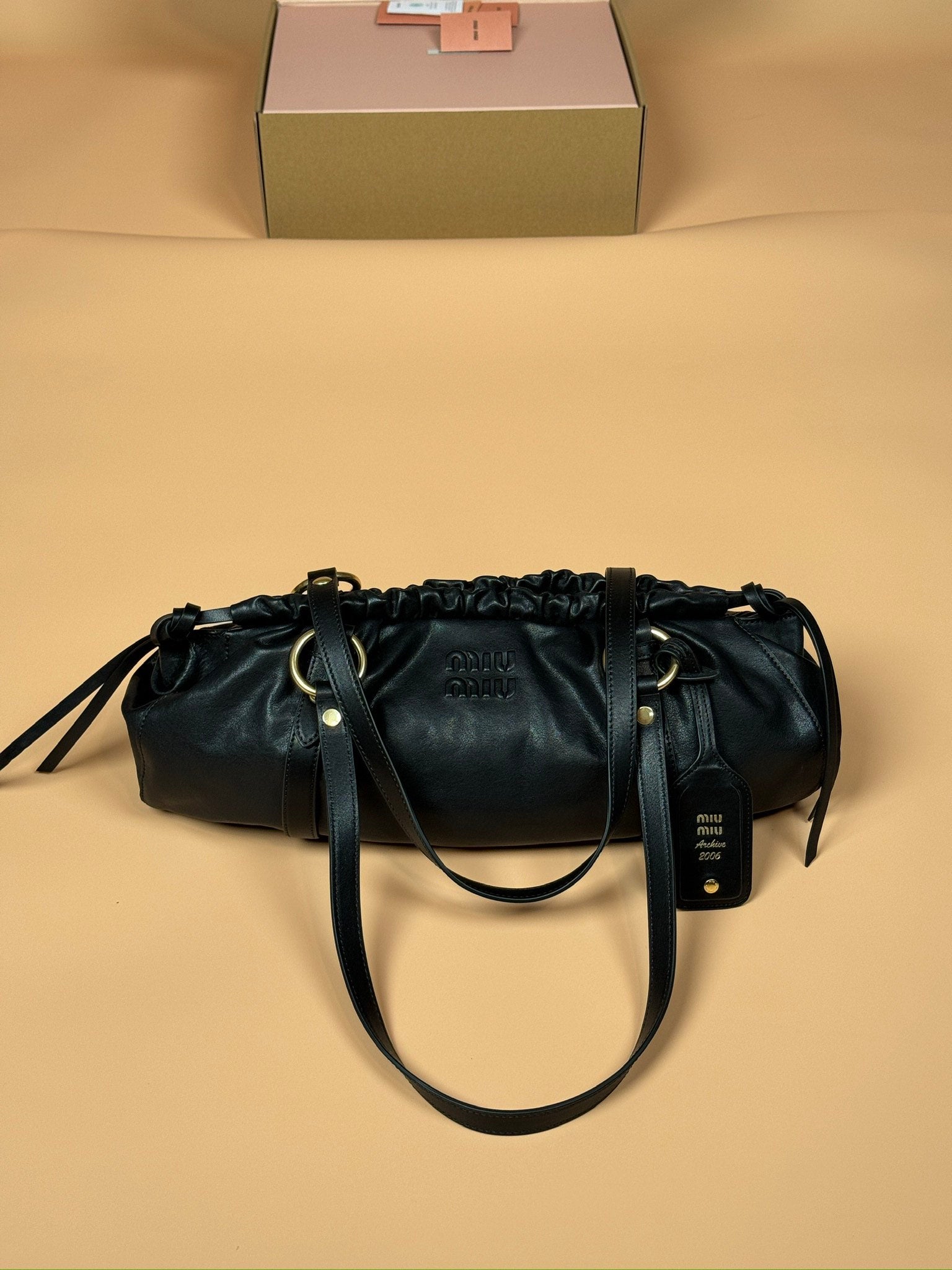 Miu Miu black bucket bag with drawstring closure and gold-tone hardware