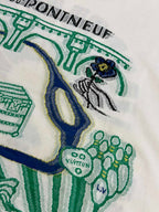 White T-shirt fabric with green and blue illustrated design near the chest