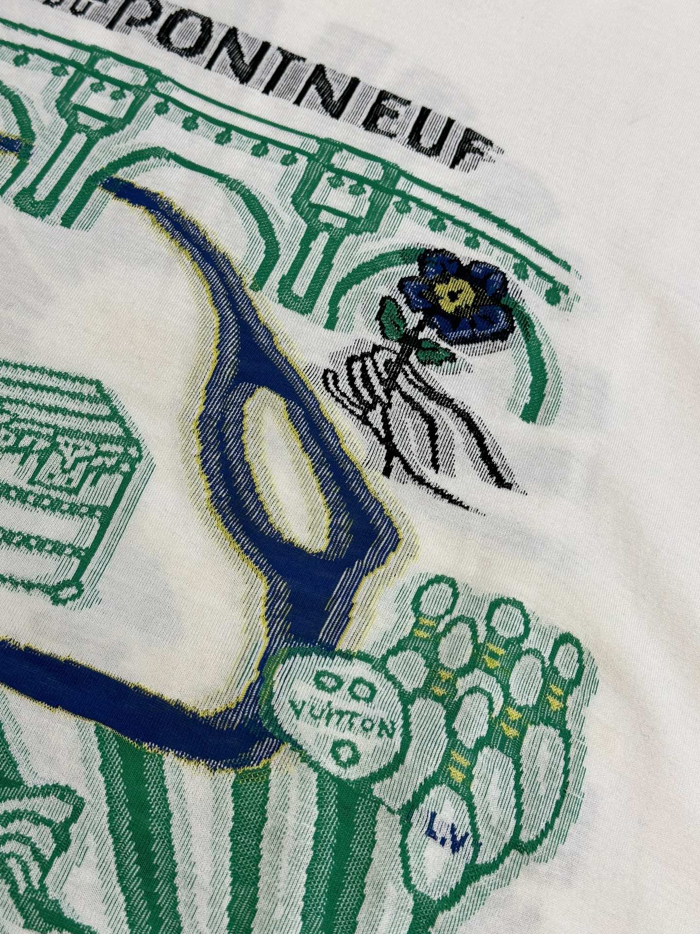 White T-shirt fabric with green and blue illustrated design near the chest