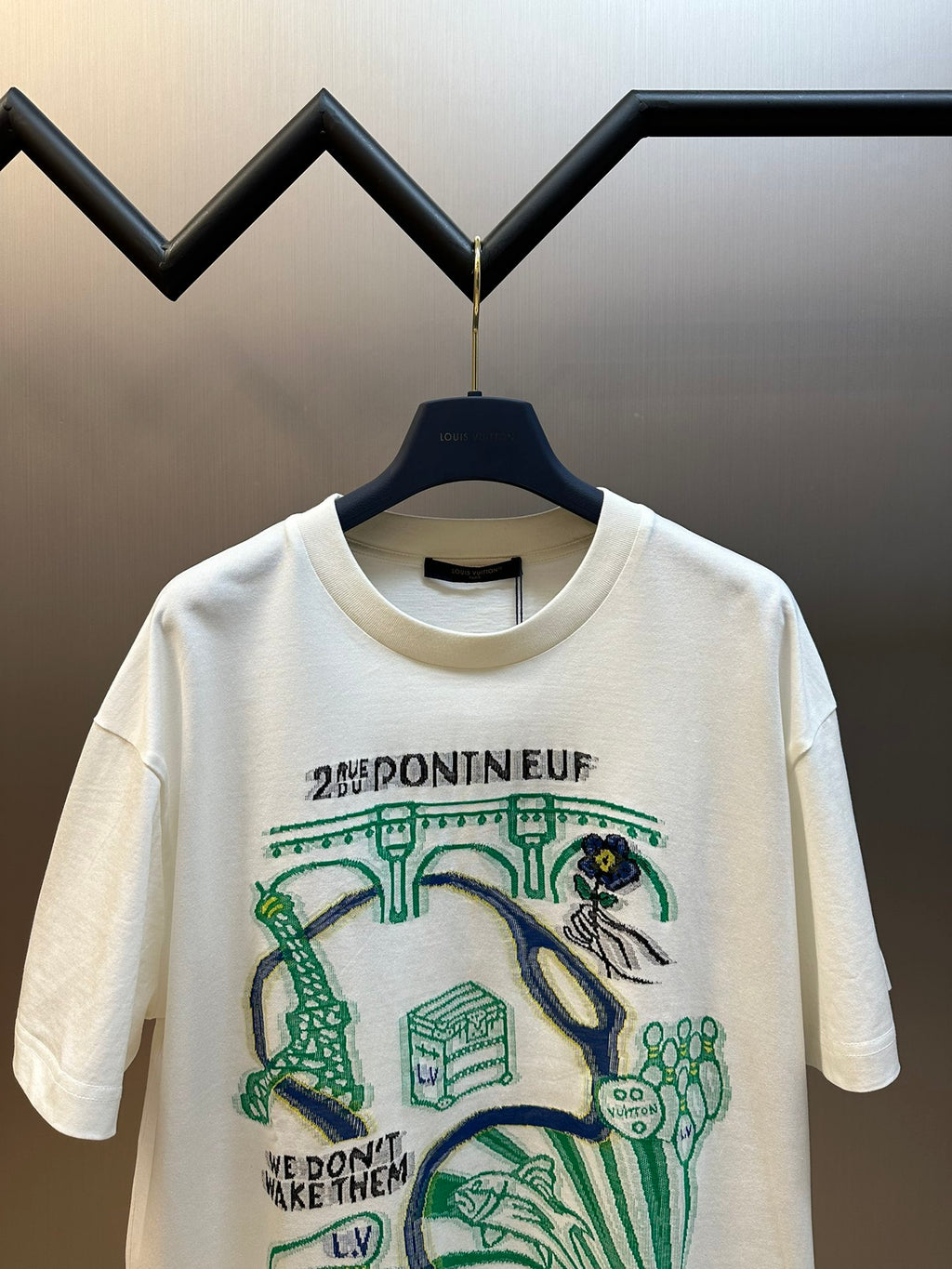 White short-sleeve T-shirt with central green and blue illustration and printed text