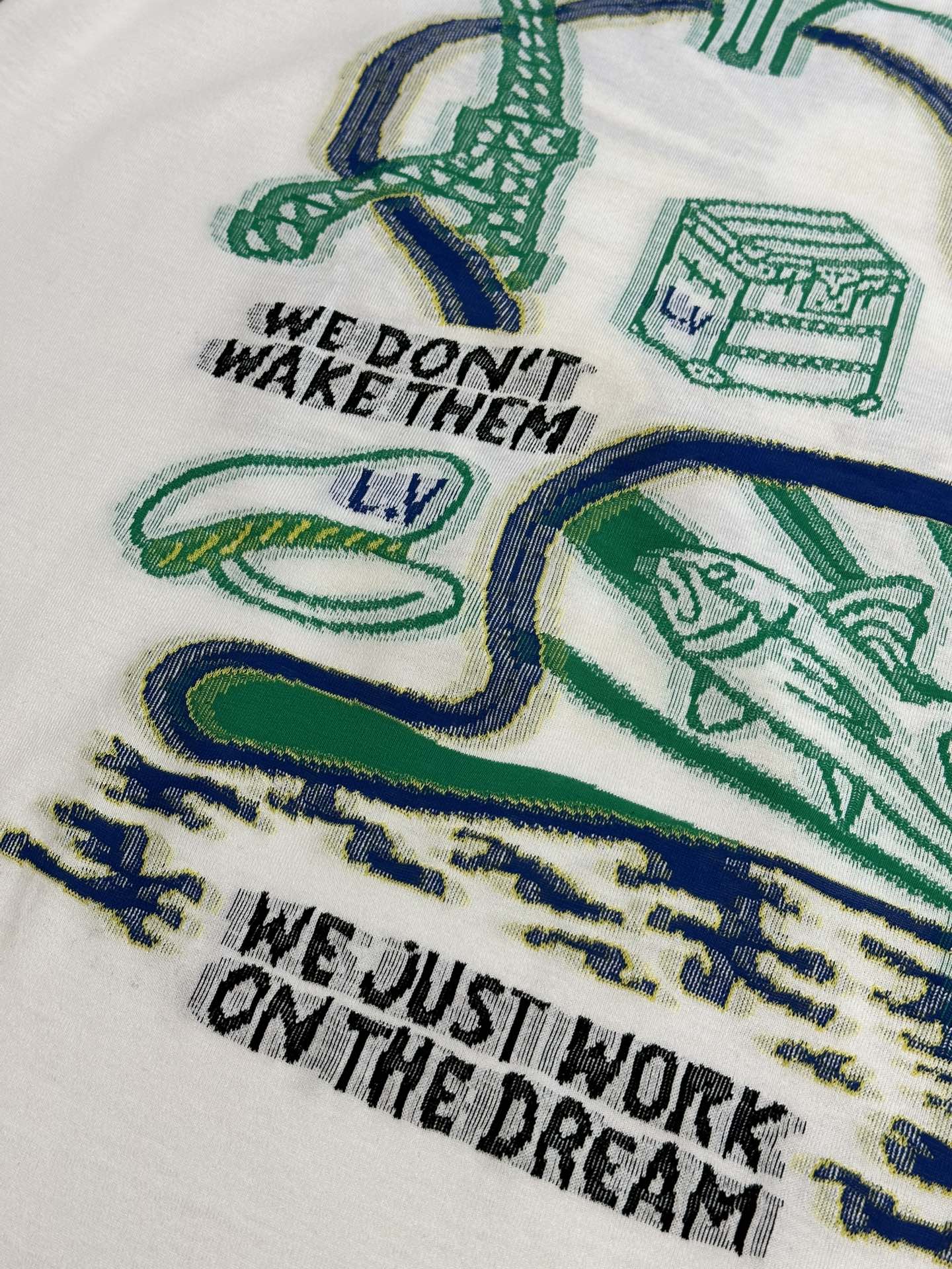 White T-shirt chest print with green-and-blue illustrations and slogan text