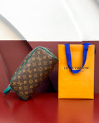 Brown monogram toiletry bag with teal trim and zipper, upright