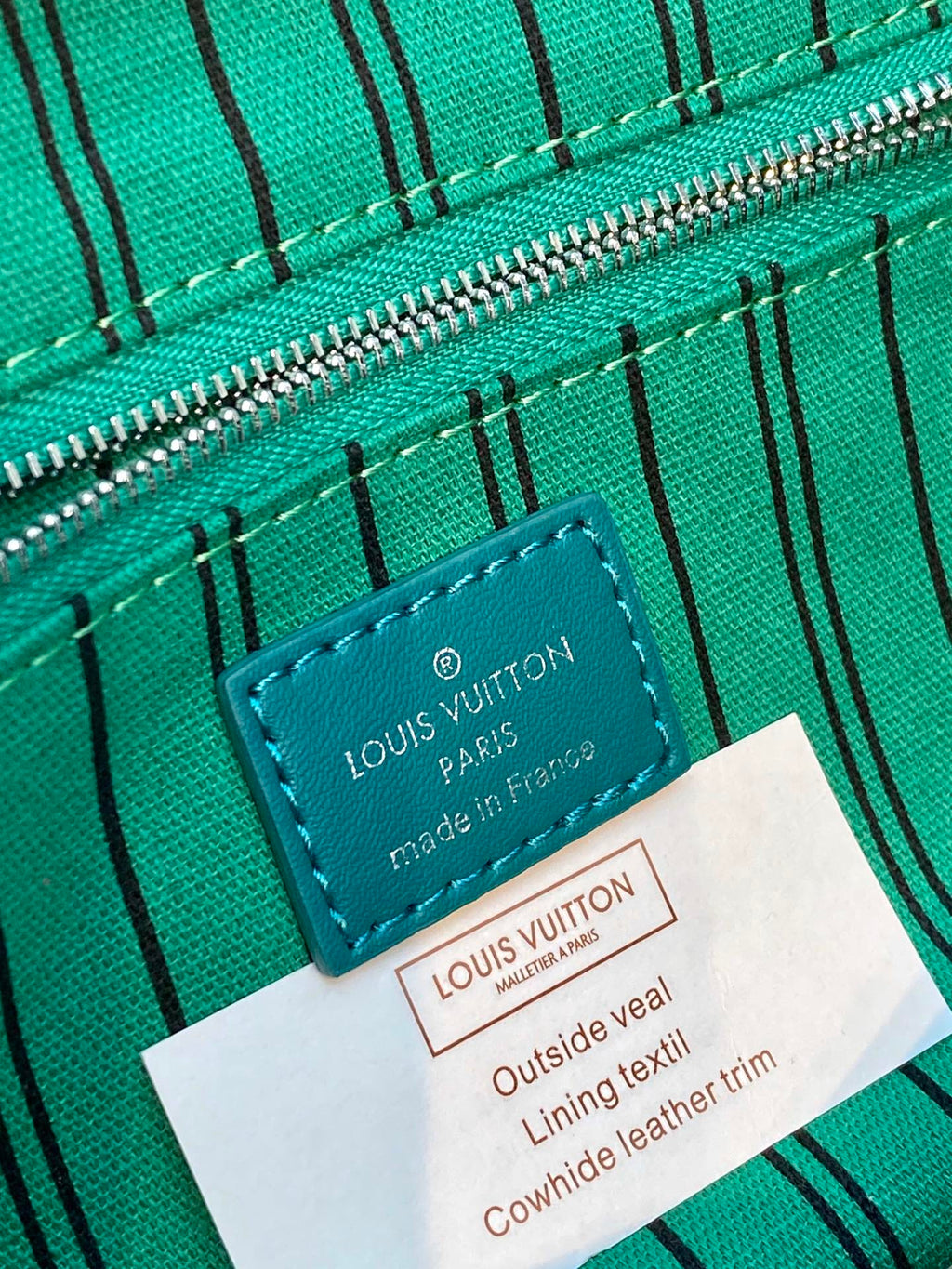 Teal lining label with Louis Vuitton branding and material text