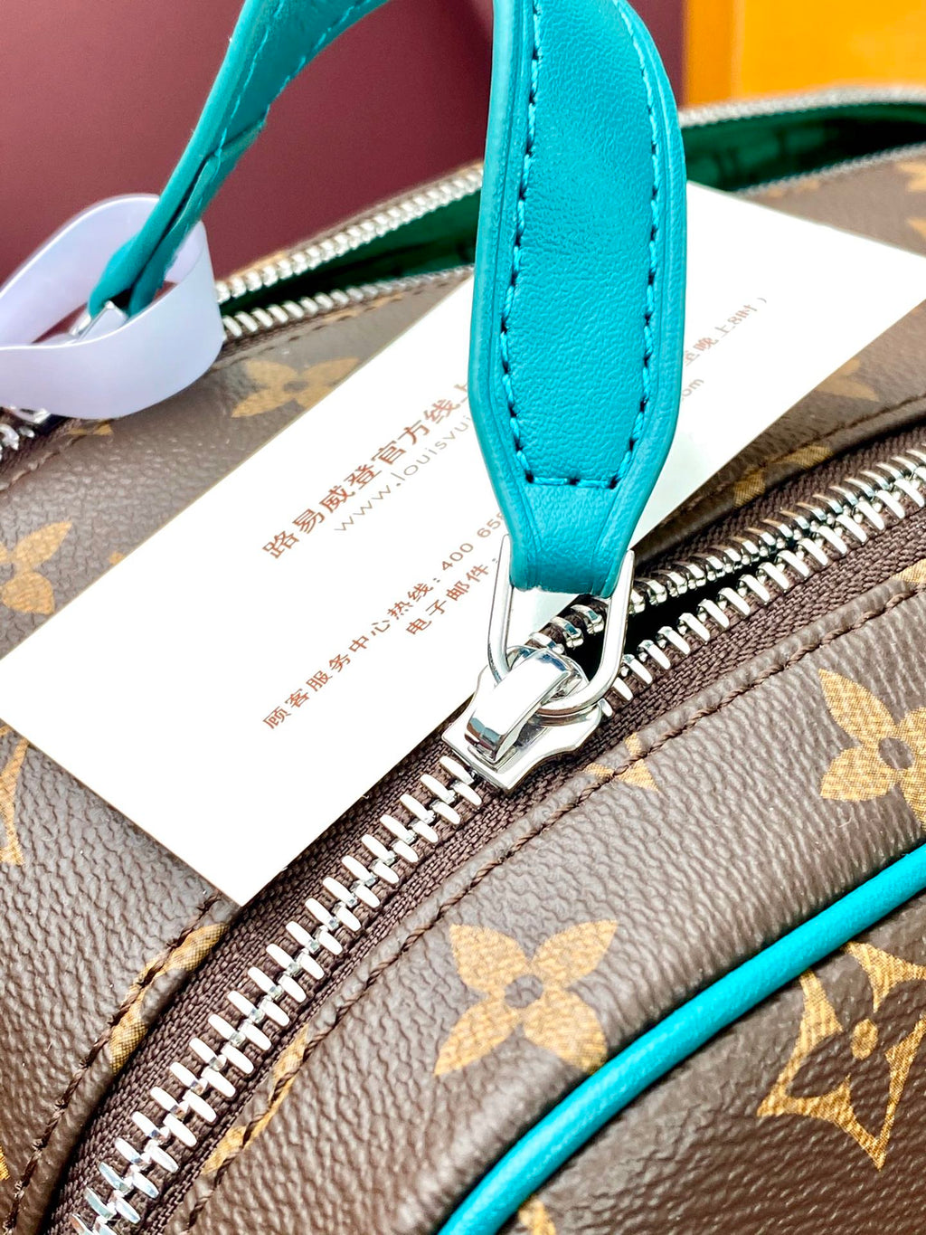 Teal leather zipper pull and ring on monogram pouch