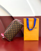 Louis Vuitton monogram toiletry bag with pink strap, shown with branded shopping bag