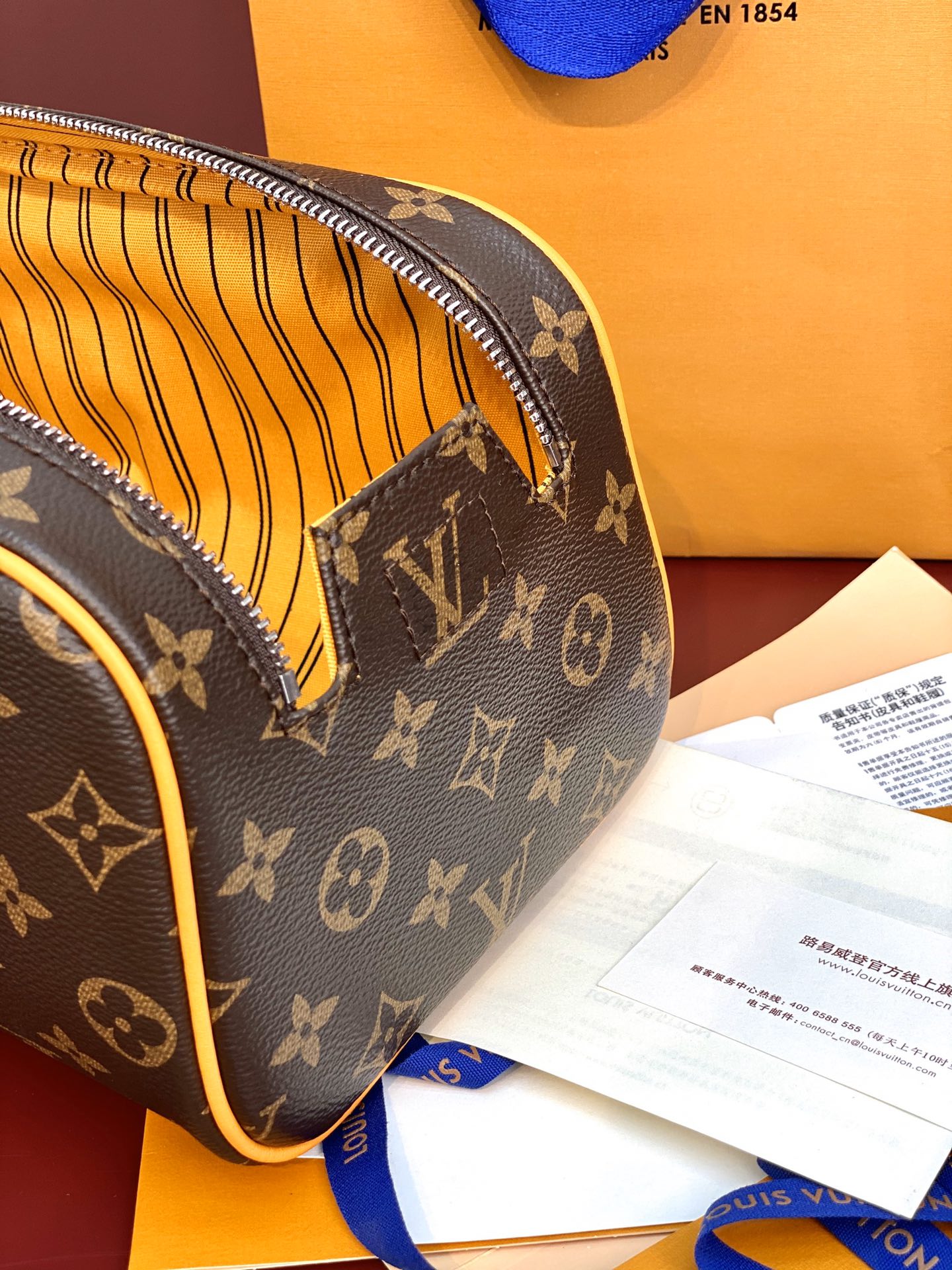Louis Vuitton monogram toiletry bag corner with yellow striped interior lining