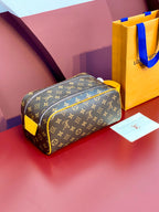 Louis Vuitton monogram toiletry bag with yellow trim, front view, zip closure