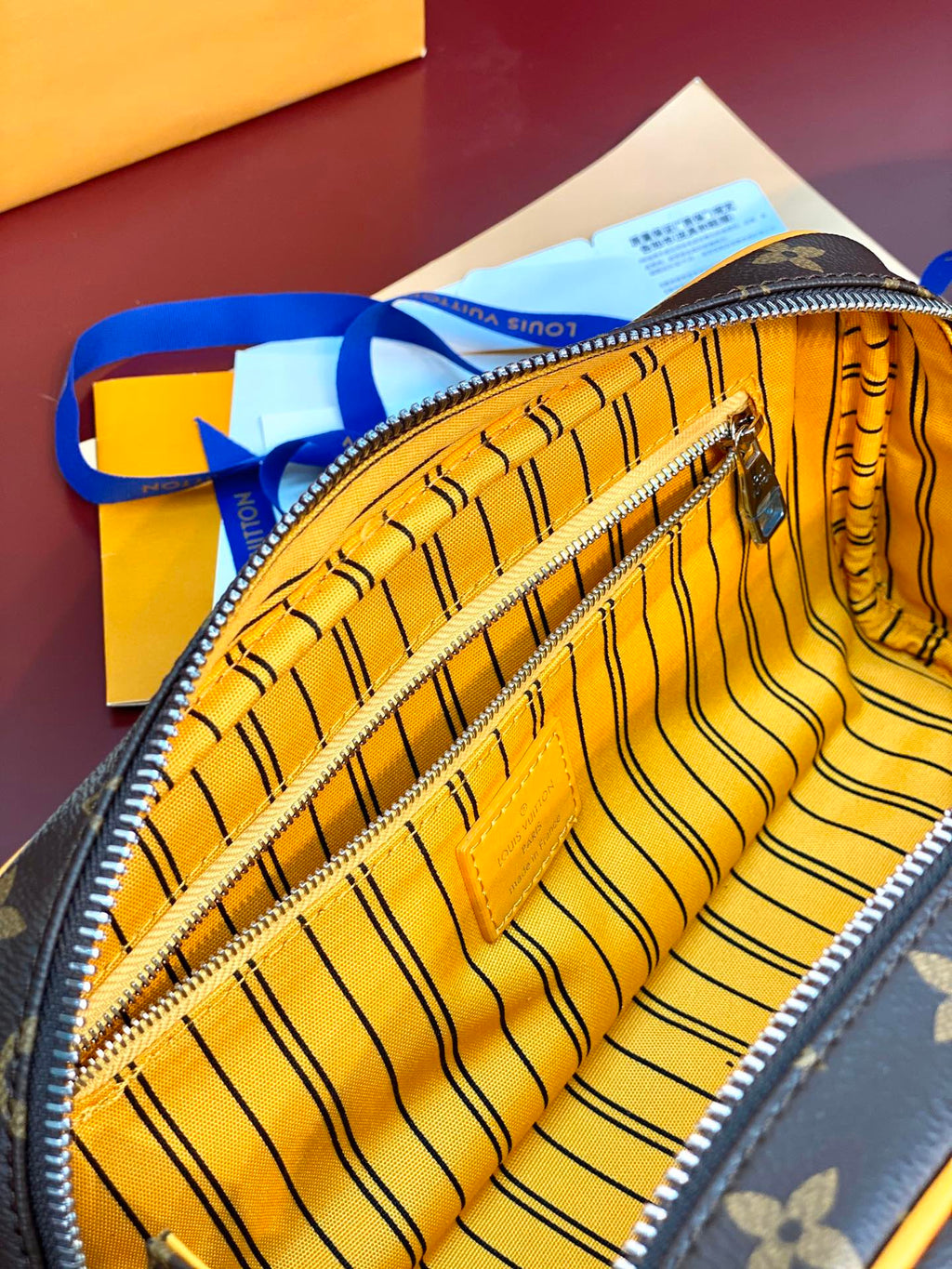 Louis Vuitton toiletry bag with striped yellow lining and zippered interior