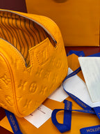 Louis Vuitton small yellow crossbody bag with embossed monogram, top zipper and leather strap