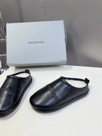 Black leather slide sandals with curved toe and open heel