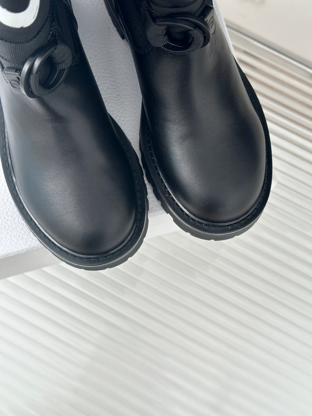 Black leather ankle boots close-up with round toe and lace strap