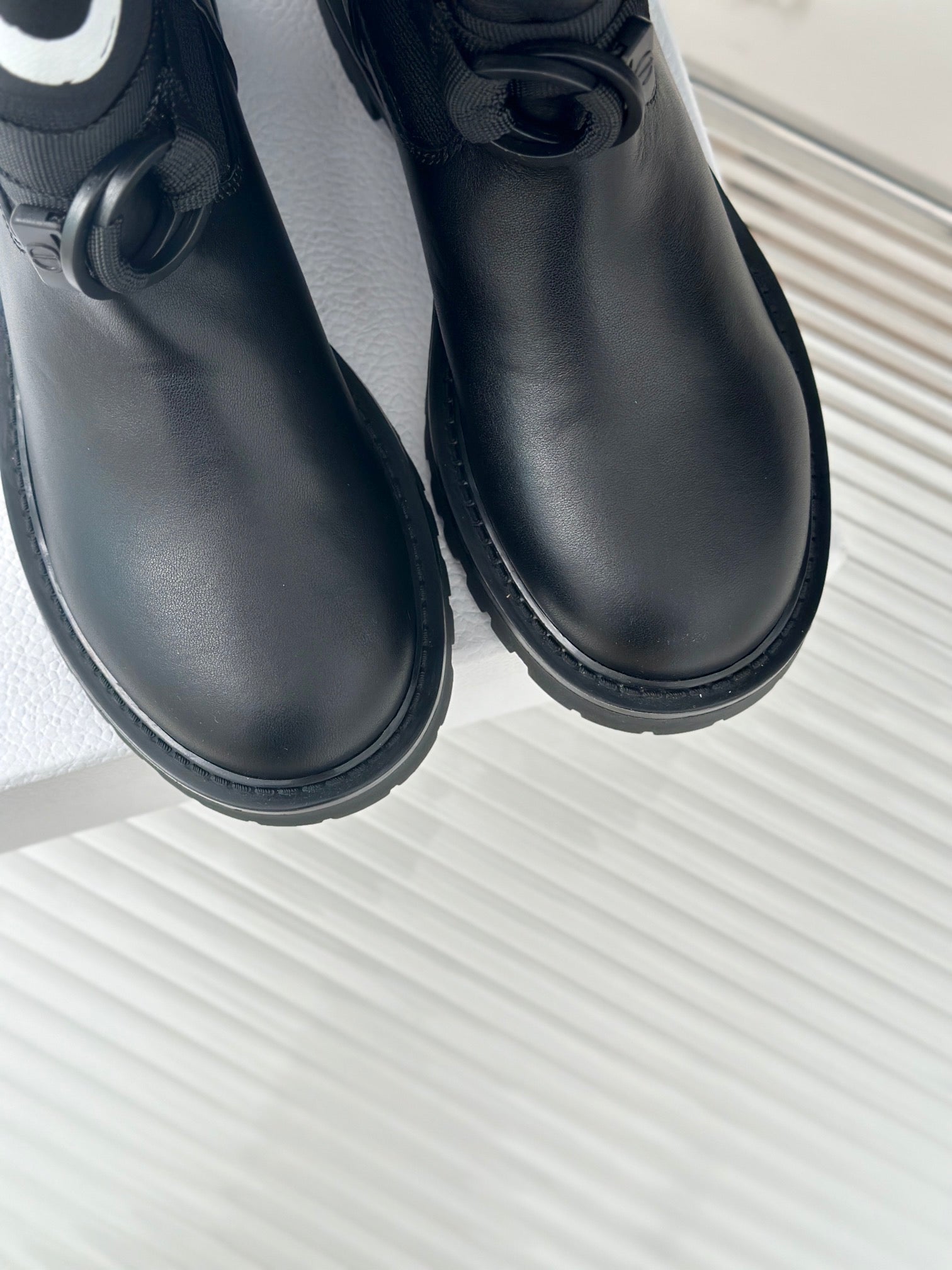 Black leather ankle boots close-up with round toe and lace strap
