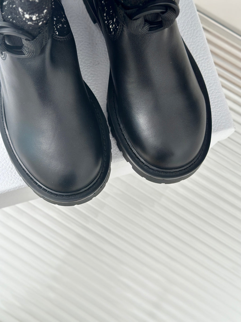 Black leather ankle boots with thick tread sole and rounded toe