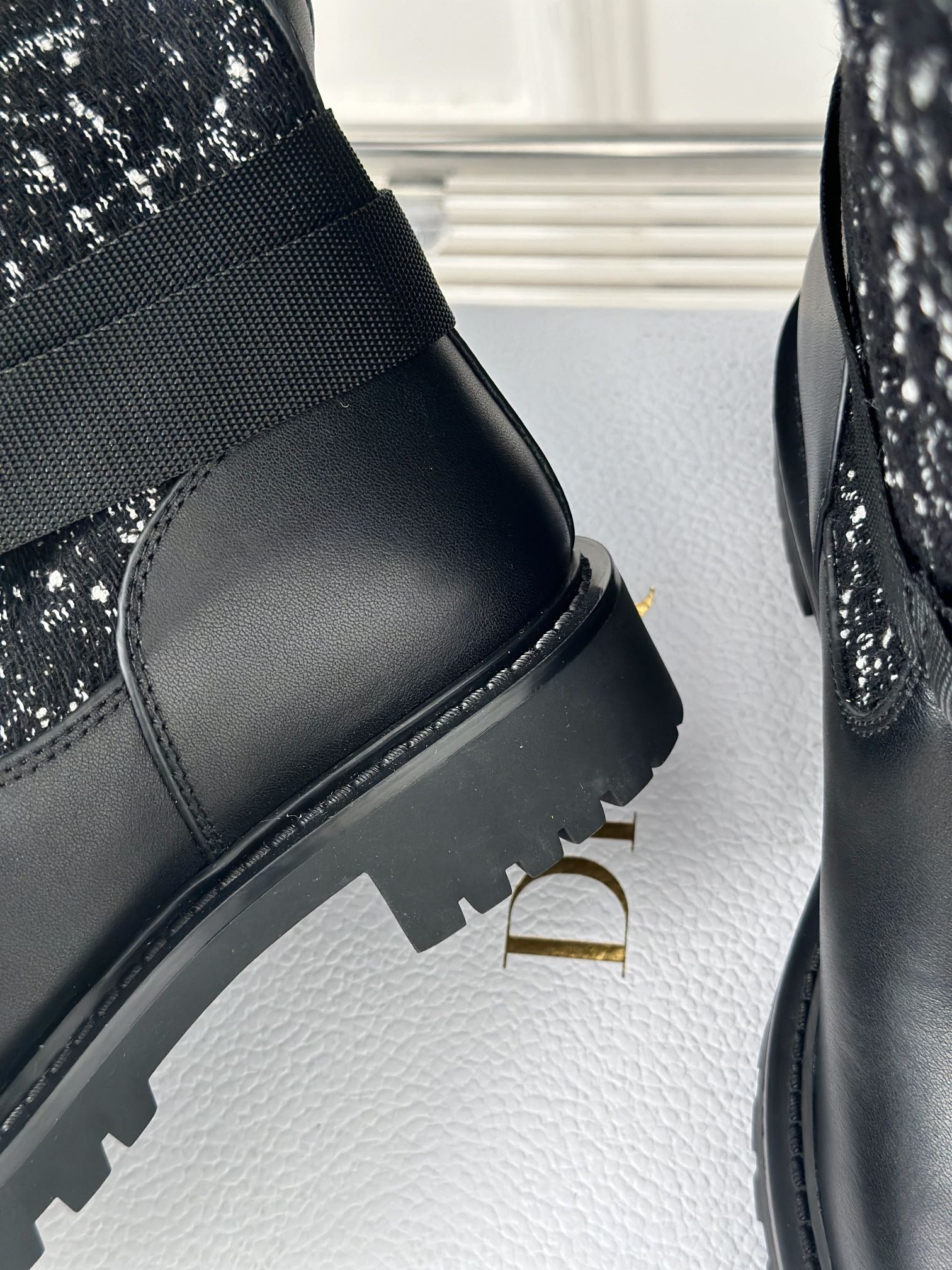 Black boot with smooth leather upper and ribbed sole edge detail