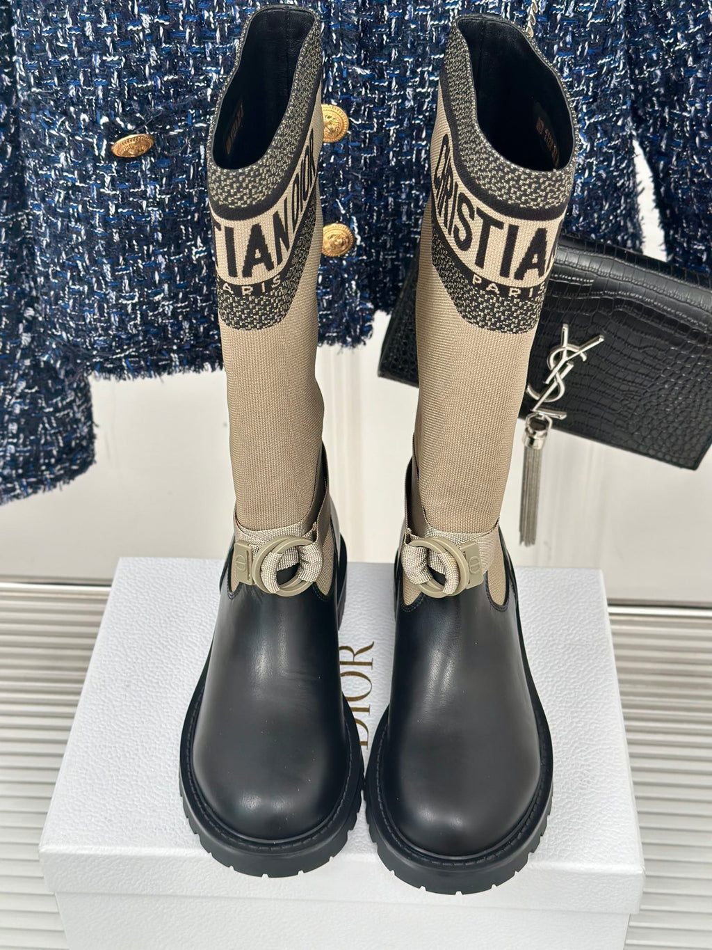Women’s Dior ankle boots front view, beige knit shaft and black leather with buckle straps