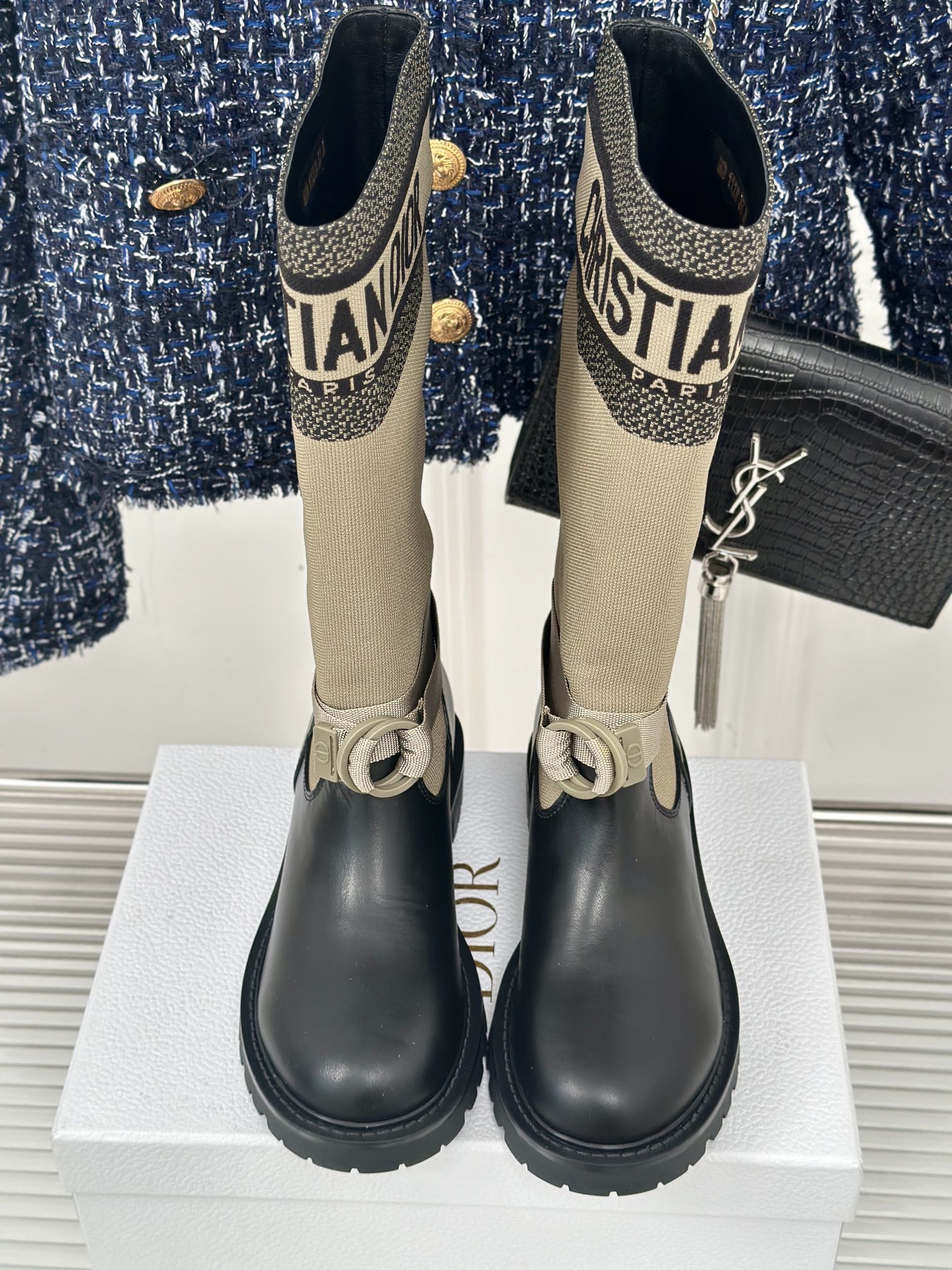 Women’s Dior ankle boots front view, beige knit shaft and black leather with buckle straps