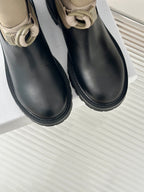 Women’s Dior ankle boots close-up, black leather uppers with beige top cuff and buckle
